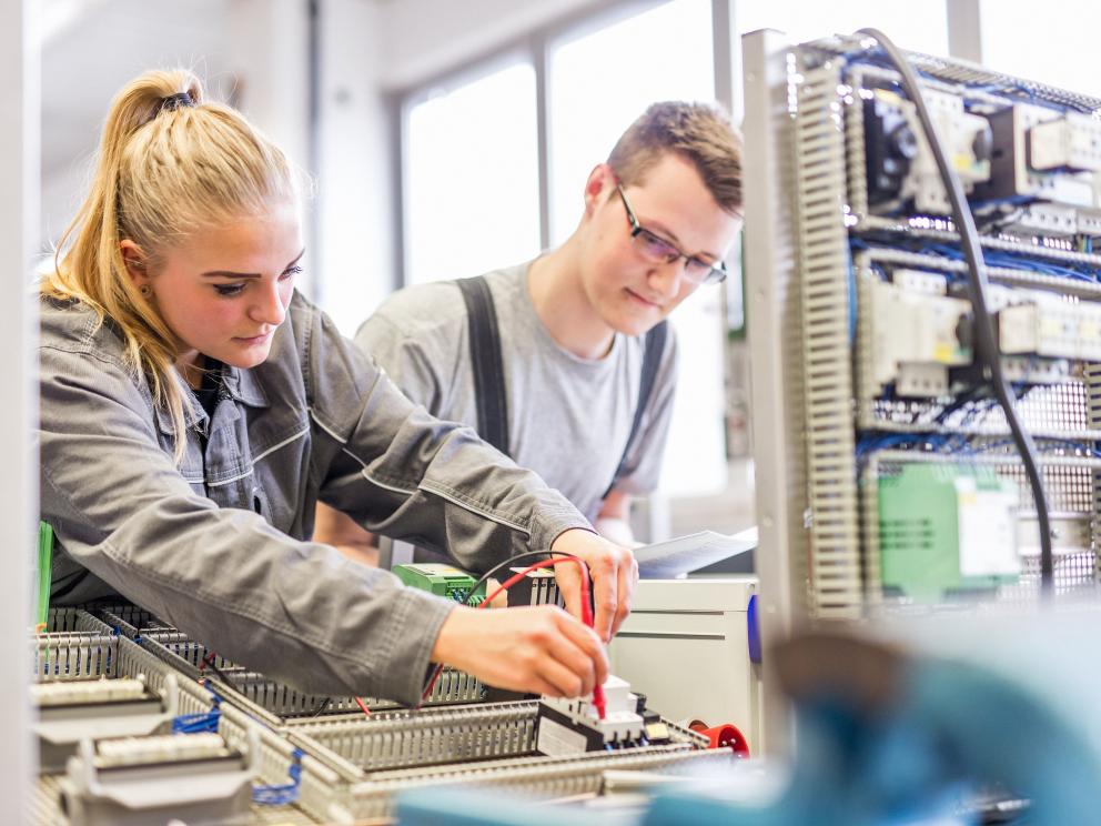 Uniper Auszubildender und Auszubildende arbeiten in Werkstatt an Elektronikteil