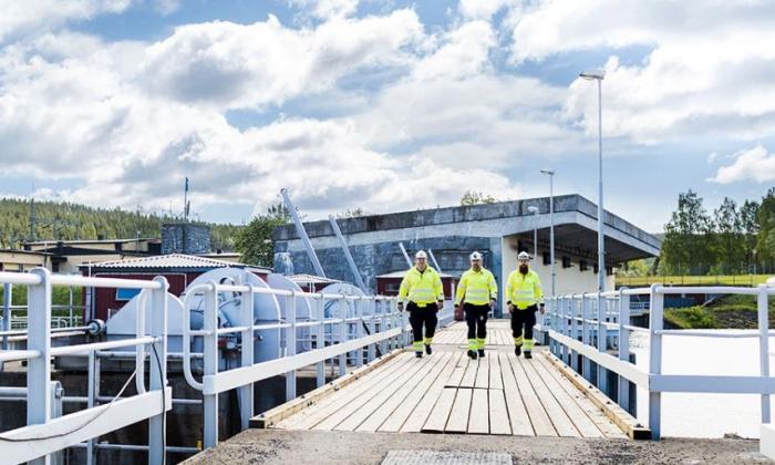 Three engineers walking across a platform at a Hydro plant in Sweden