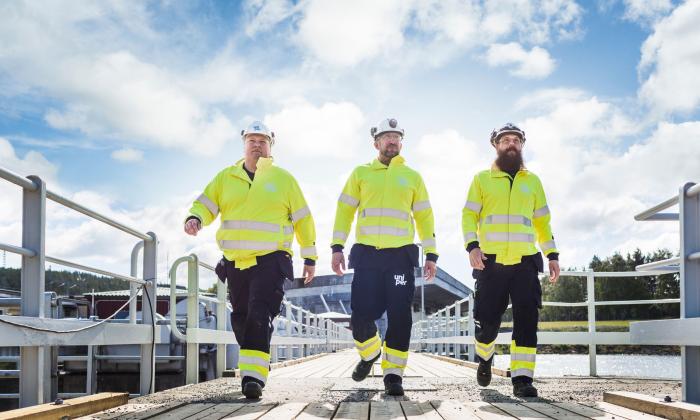 Three male Uniper workers with helmets at a hydropower plant