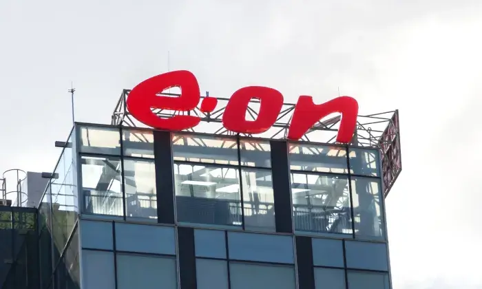 The E.ON logo displayed on the top of a modern glass building, with a cloudy sky in the background.