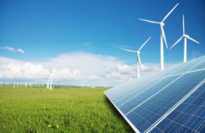 Image of solar panels in the foreground and wind turbines in the background