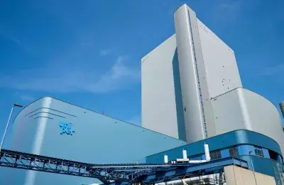 Exterior view of the MPP3 power plant at Uniper's Maasvlakte Energy Hub, featuring modern blue and white industrial architecture against a clear blue sky.