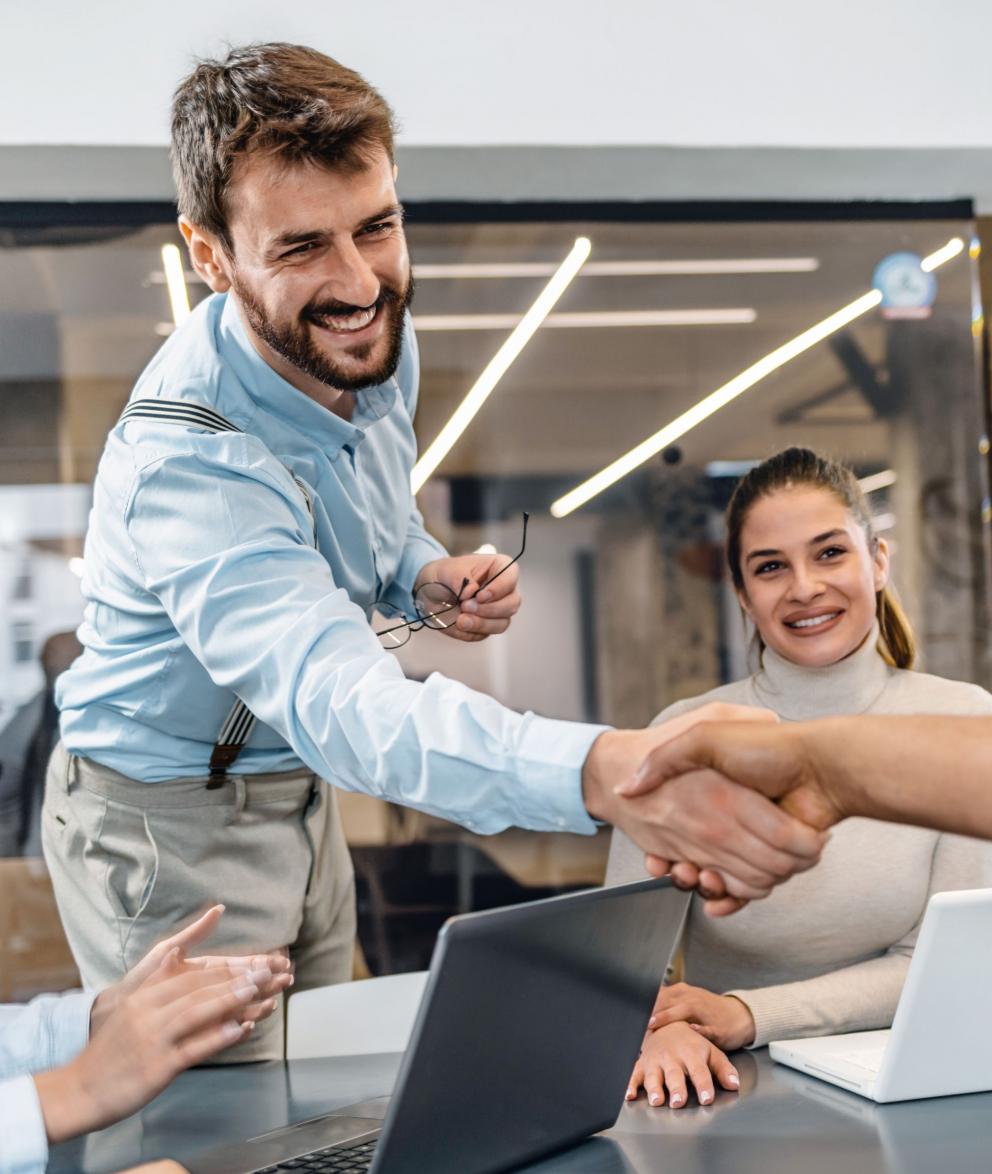 Colleagues shaking hands at a board meeting