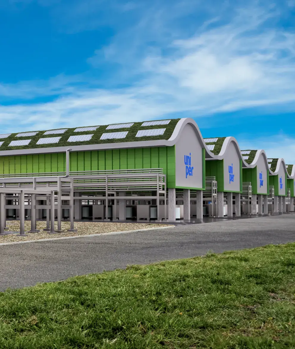  A row of modern Uniper industrial buildings with green roofs and solar panels under a bright blue sky.
