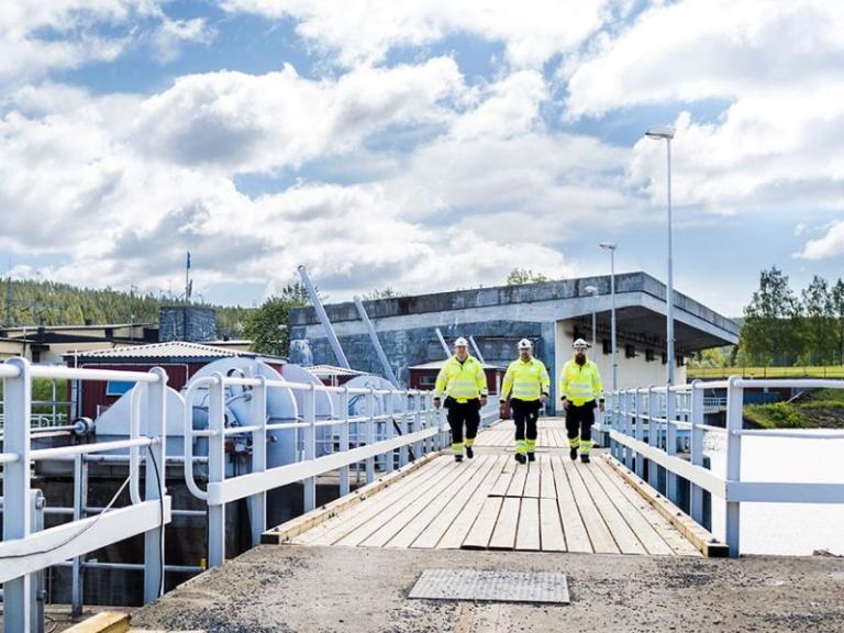 Three engineers walking across a platform at a Hydro plant in Sweden