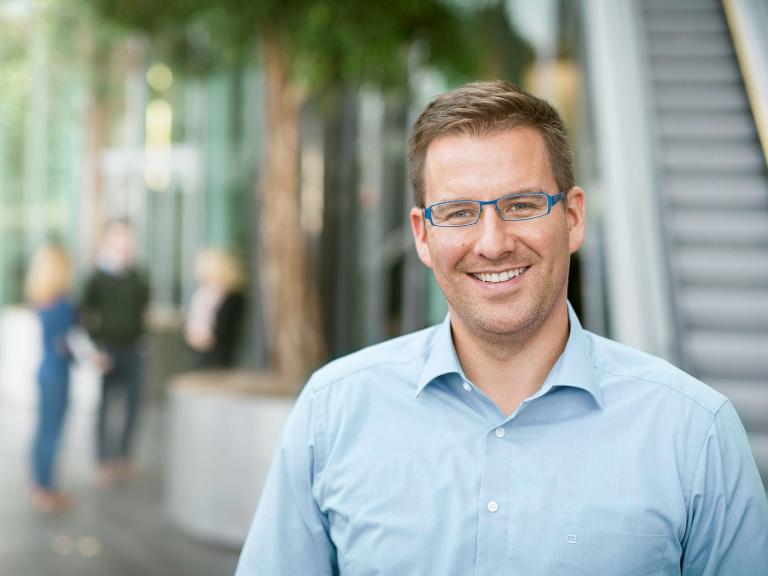 Employee smiling outside the Uniper office in Düsseldorf