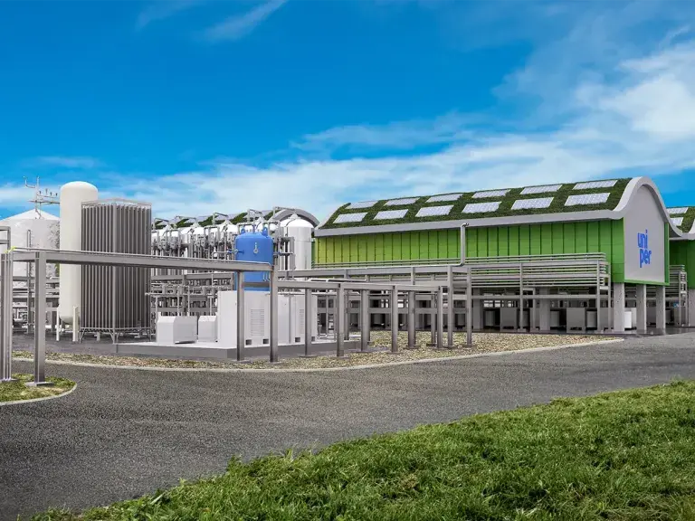 A modern industrial facility with Uniper branding, featuring green-roofed buildings and various large equipment structures, under a bright blue sky.