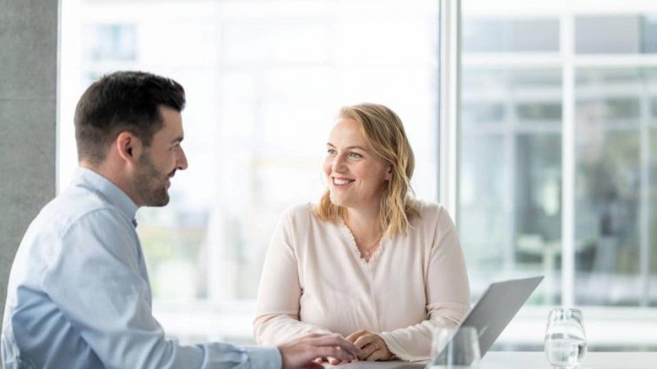 Mann und Frau in Besprechnungsraum mit Laptop 