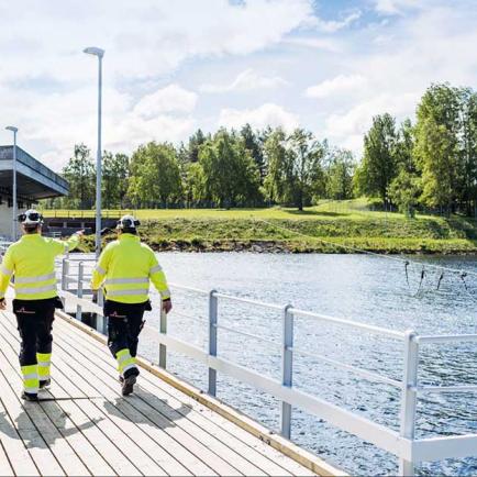 Drei männliche Uniper-Arbeiter mit Helmen in einem Wasserkraftwerk