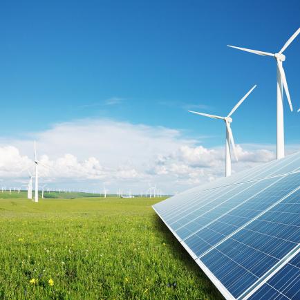 Image of solar panels in the foreground and wind turbines in the background