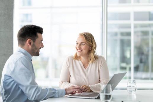 Mann und Frau in Besprechnungsraum mit Laptop