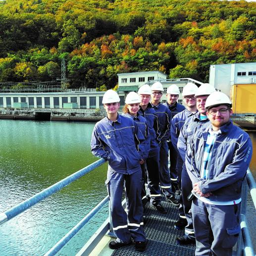 Eight technical apprentices with helmets in a hydropower plant