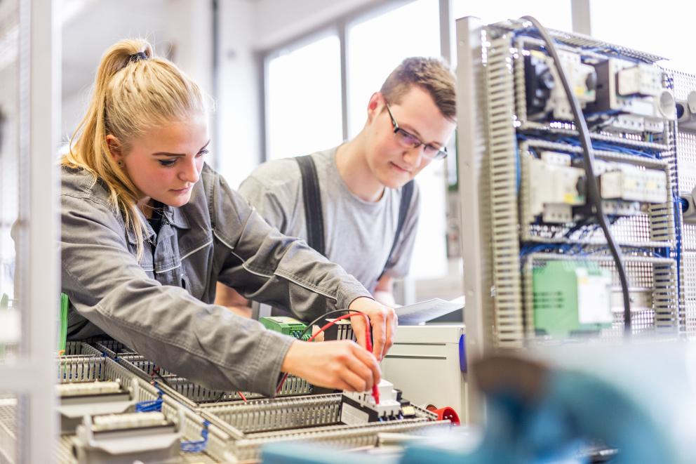 Male and female Uniper apprentices work on electronic parts in the workshop