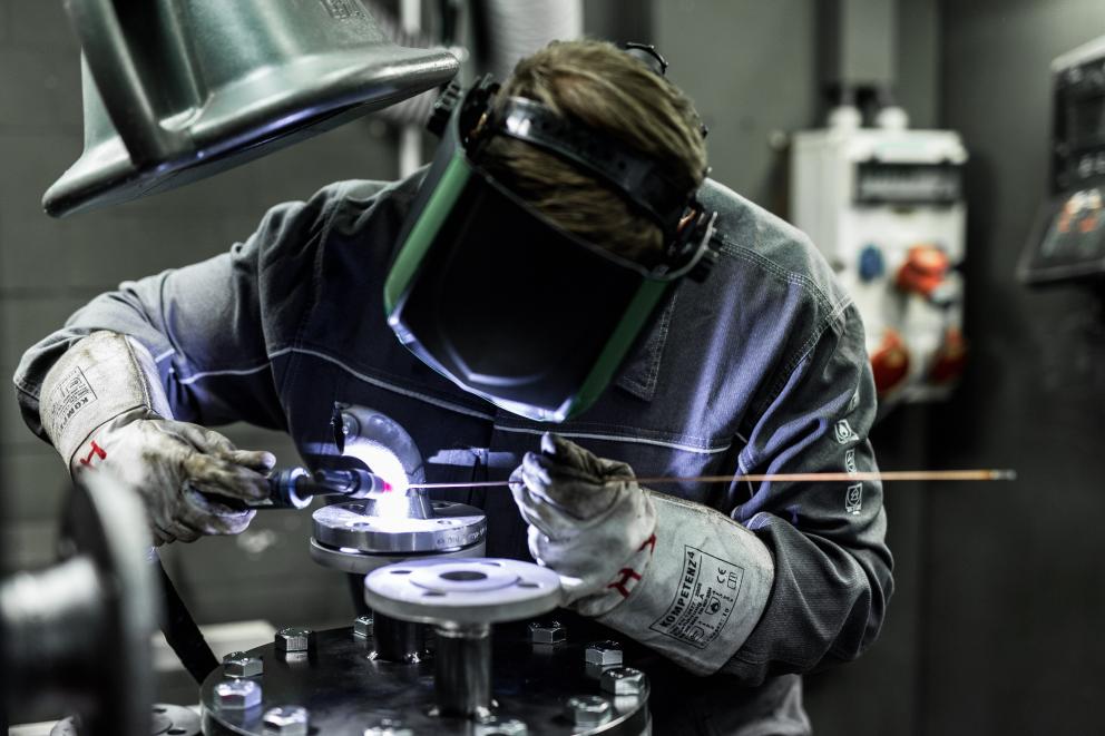 Technical apprentice with welding mask welding in the workshop