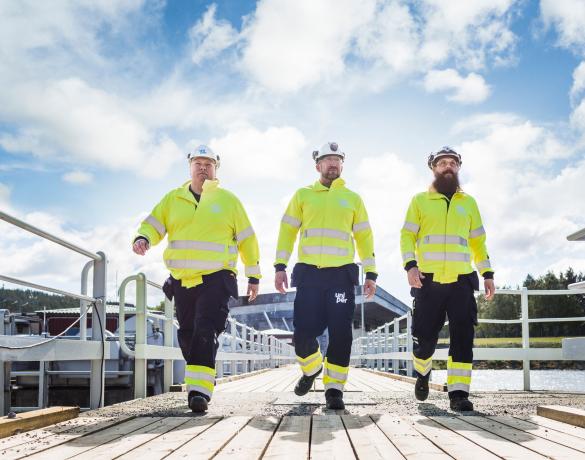 Drei männliche Uniper Arbeiter mit Helmen in einem Wasserkraftwerk