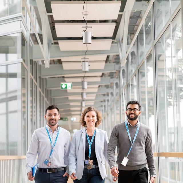 Uniper employees walking side by side in front of a glass building